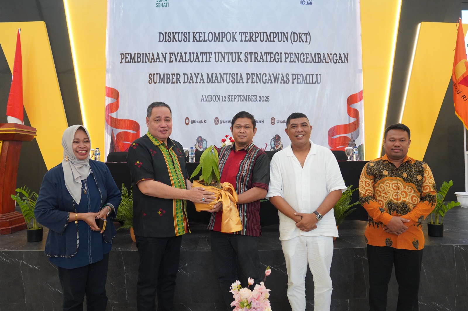 Anggota Bawaslu Herwyn JH Malonda menyerahkan secara simbolis di kegiatan Diskusi Kelompok Terpumpun (DKT) Pembinaan Evaluasi Strategi Pengembangan SDM Pengawas Pemilu yang digelar di Kota Ambon, Jumat (12/9/2025)