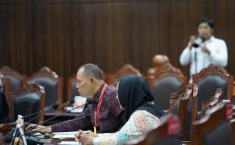 Anggota Bawaslu Totok Hariyono (kiri berbaju merah) saat menghadiri sidang pendahuluan Perselisihan Hasil Pemilihan Umum (PHPU) Kabupaten Bangka yang digelar di Mahkamah Konstitusi (MK), Kamis (18/9/2025). 